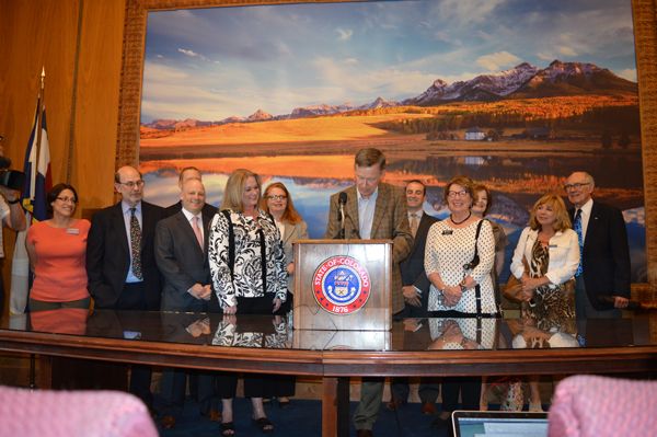 Attorney Shari Caton looks on as Governor Hickenlooper signs the “Achieving Better Life Experience” (ABLE) legislation.